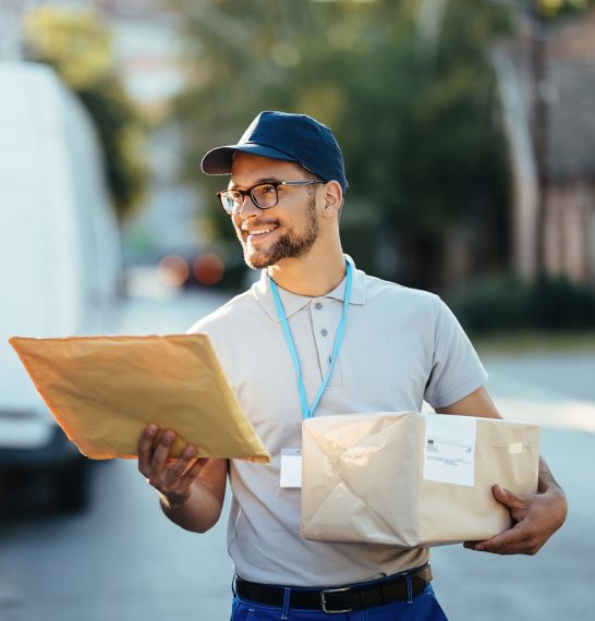 happy-delivery-man-carrying-packages-while-walking-down-street